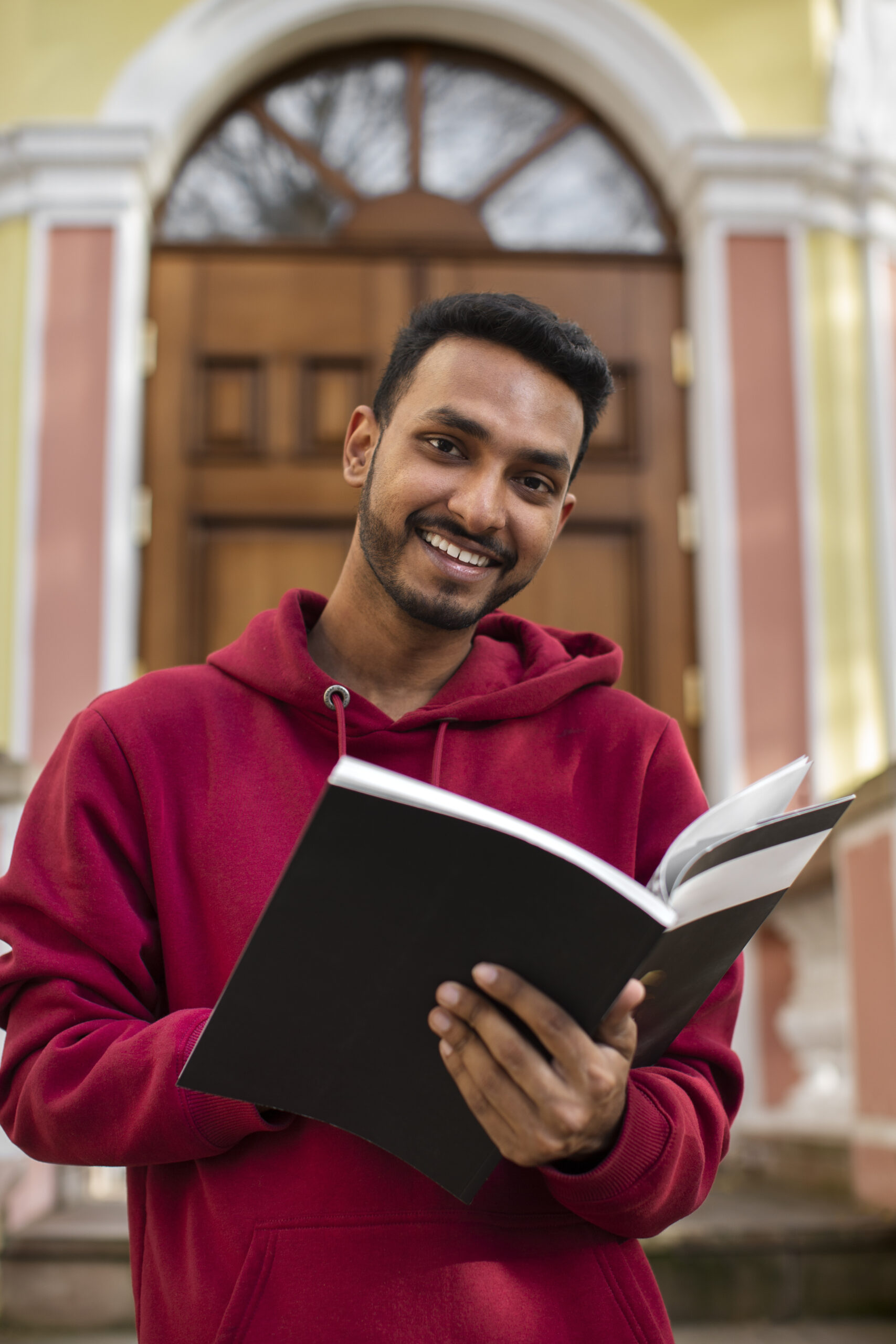 smiley man holding book front view scaled